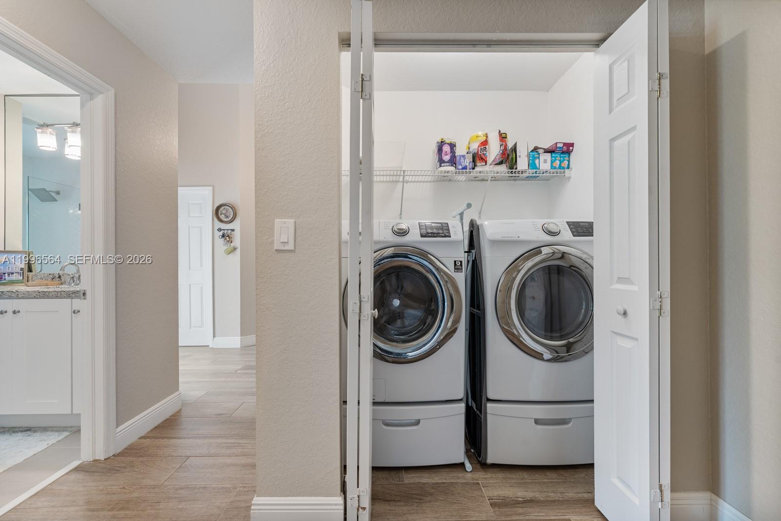 9473 Southwest 227th Terrace Cutler Bay, FL 33190 - Photo 18 of 31 a utility room with dryer washer and a view of kitchen