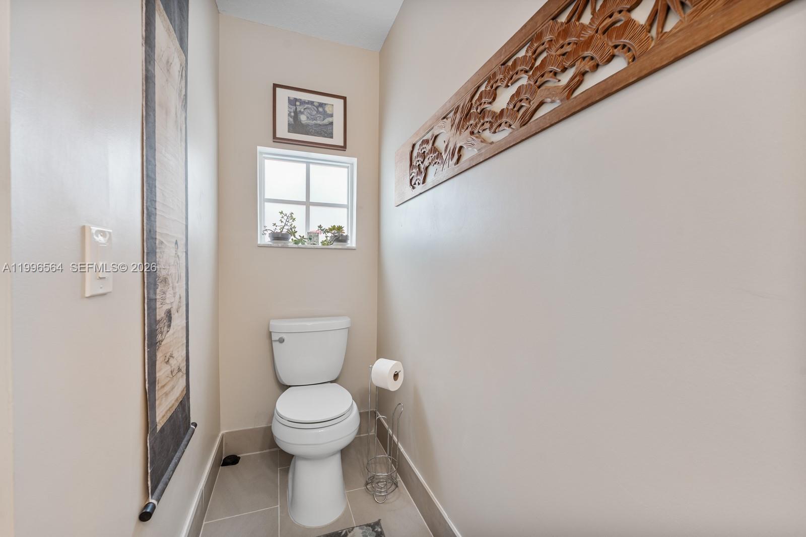 9473 Southwest 227th Terrace Cutler Bay, FL 33190 - Photo 20 of 31 a bathroom with a toilet and a window