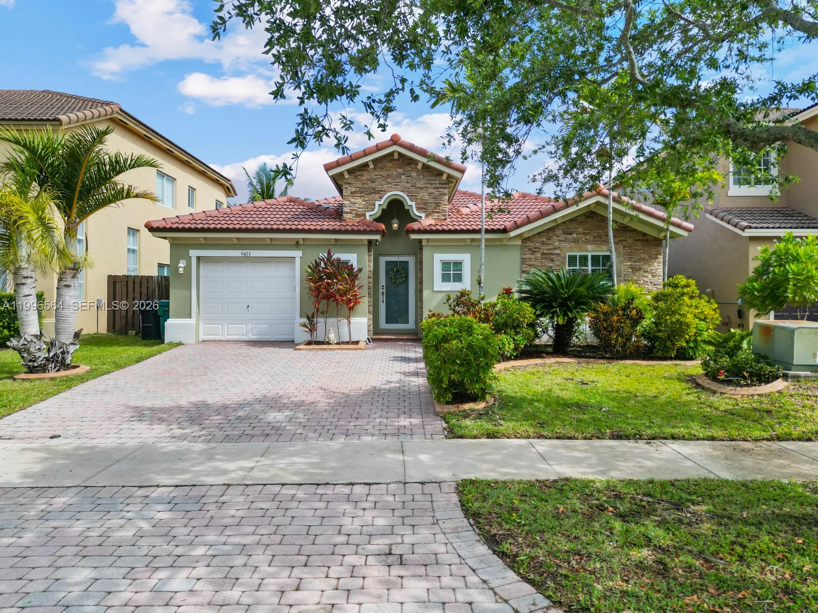 9473 Southwest 227th Terrace Cutler Bay, FL 33190 - Photo 31 of 31 a front view of a house with a yard and potted plants