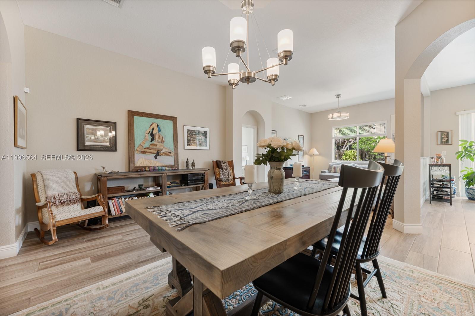 9473 Southwest 227th Terrace Cutler Bay, FL 33190 - Photo 4 of 31 a view of a dining room with furniture a chandelier and wooden floor