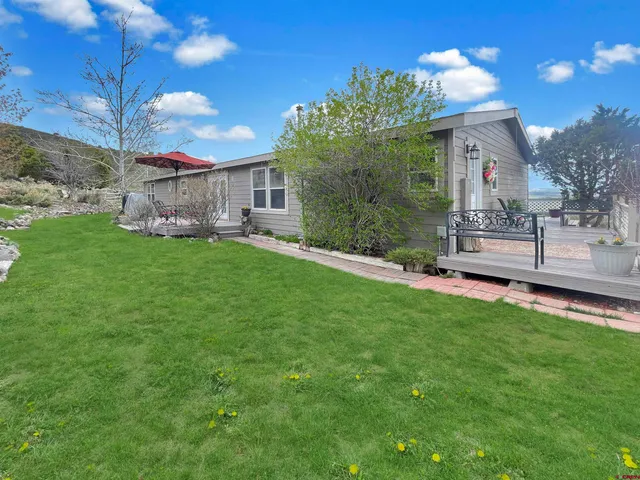 a view of a house with a yard and deck