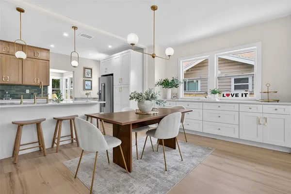 a kitchen with a dining table chairs sink and cabinets