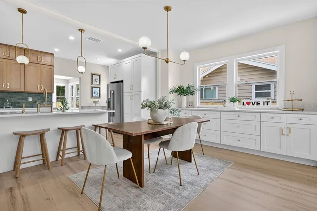 a kitchen with a dining table chairs sink and cabinets