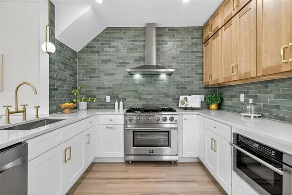 a kitchen with stainless steel appliances granite countertop a stove and white cabinets