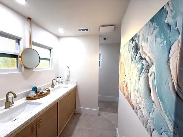 a spacious bathroom with a double vanity sink and a mirror