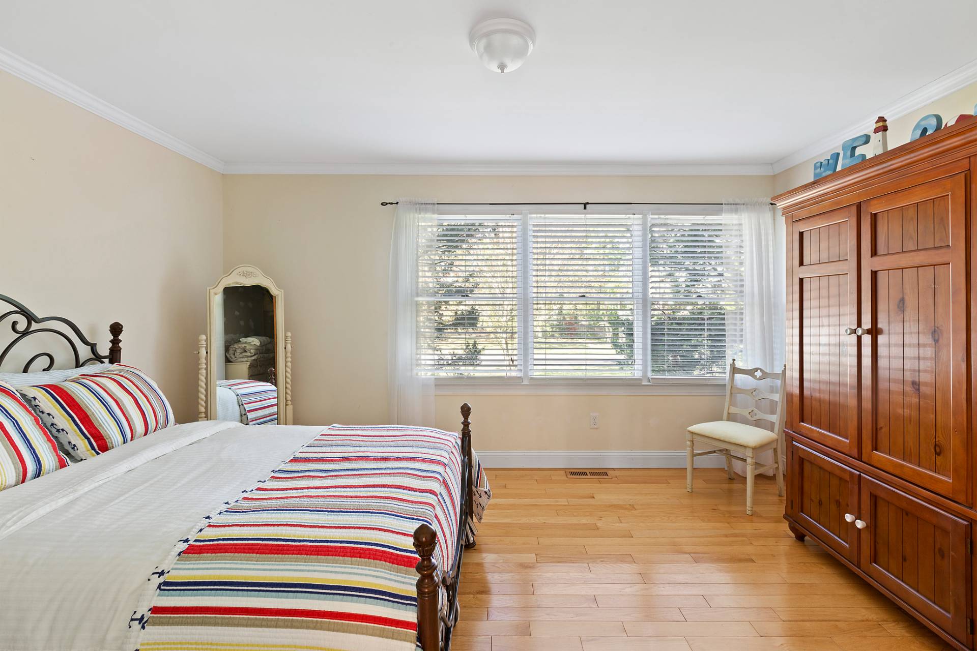 23 Whiting Road East Quogue, NY 11942 - Photo 10 of 21 a bedroom with a bed and wooden floor