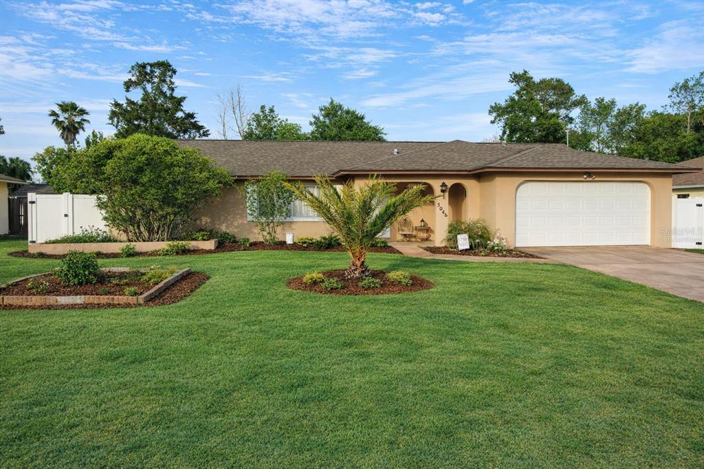 5046 Kenmore Street Spring Hill, FL 34608 - Photo 2 of 19 a view of a backyard with plants and a garden
