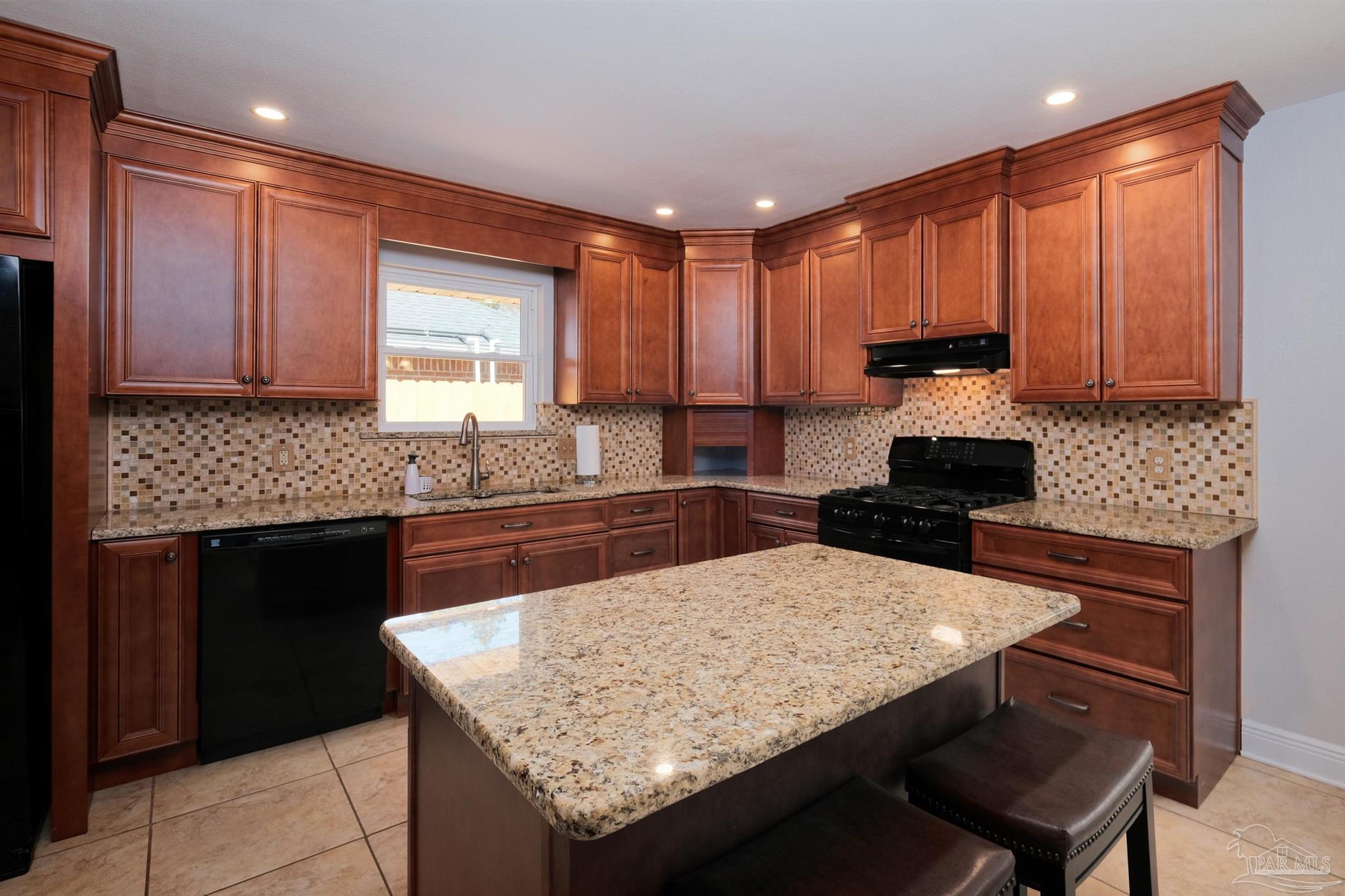 1908 Joshua Drive Cantonment, FL 32533 - Photo 17 of 47 a kitchen with granite countertop a sink a stove and cabinets