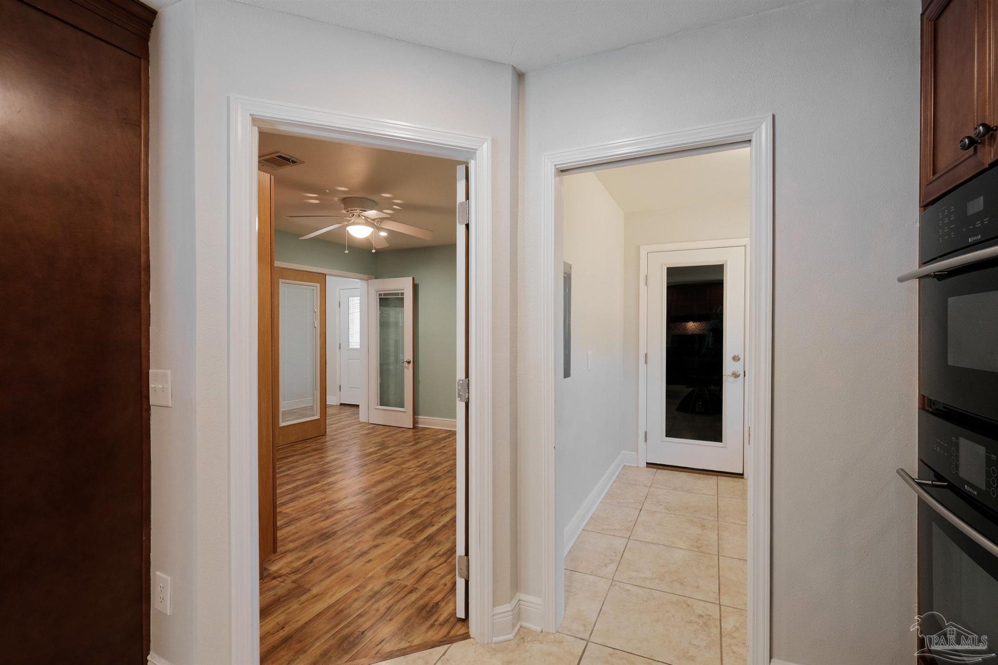 1908 Joshua Drive Cantonment, FL 32533 - Photo 18 of 47 a view of a hallway with wooden floor and a flat screen tv