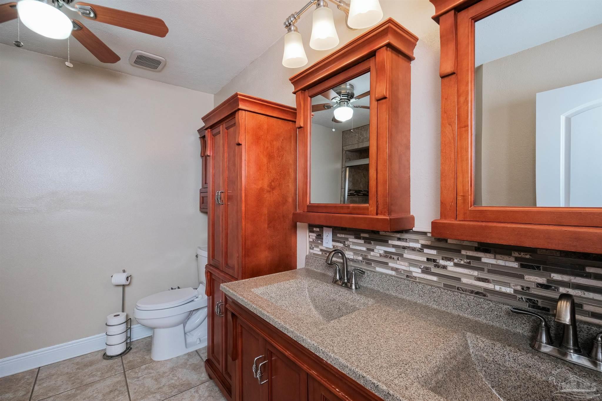 1908 Joshua Drive Cantonment, FL 32533 - Photo 28 of 47 a bathroom with a sink a toilet and mirror