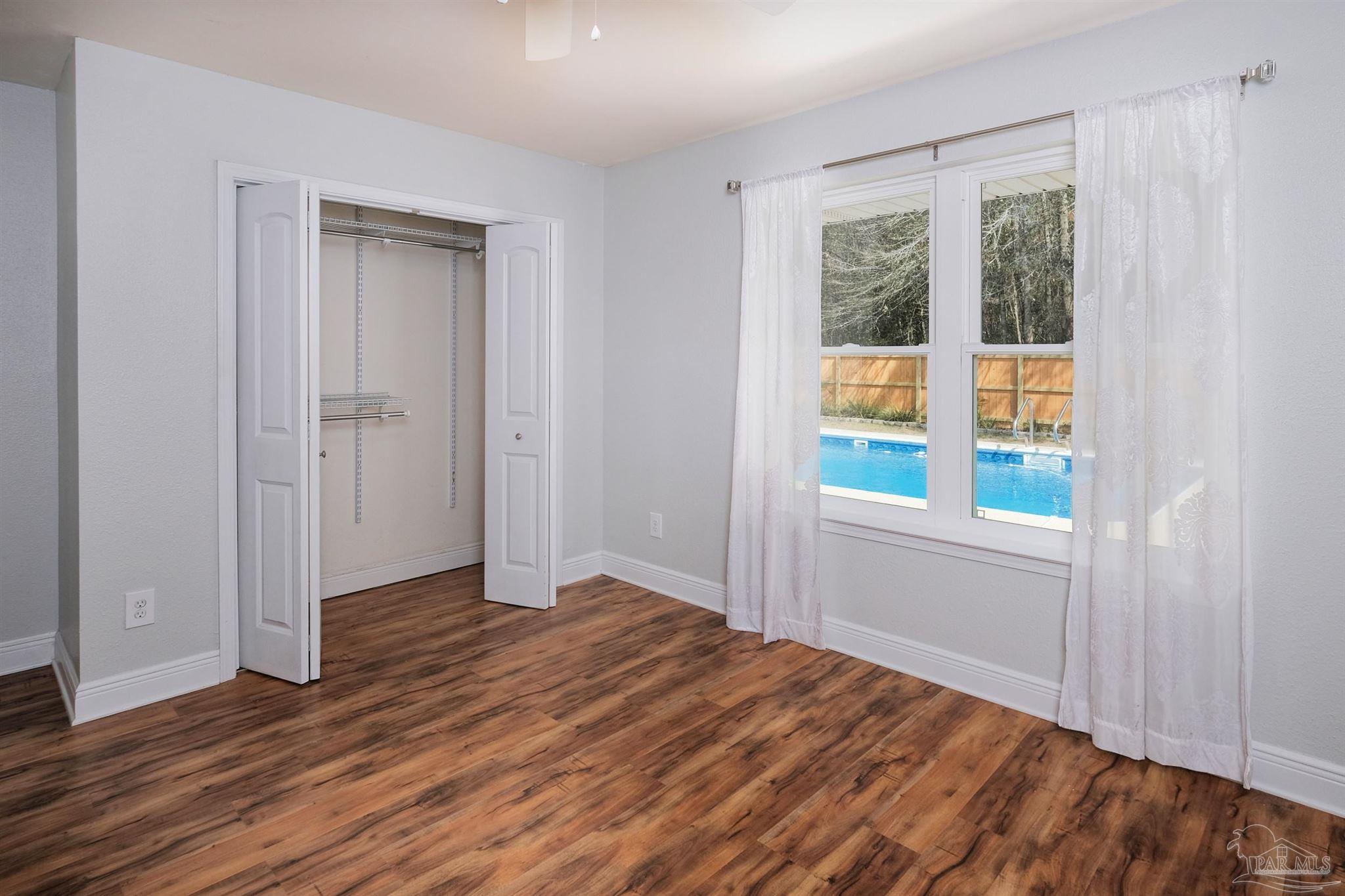 1908 Joshua Drive Cantonment, FL 32533 - Photo 38 of 47 an empty room with wooden floor and windows
