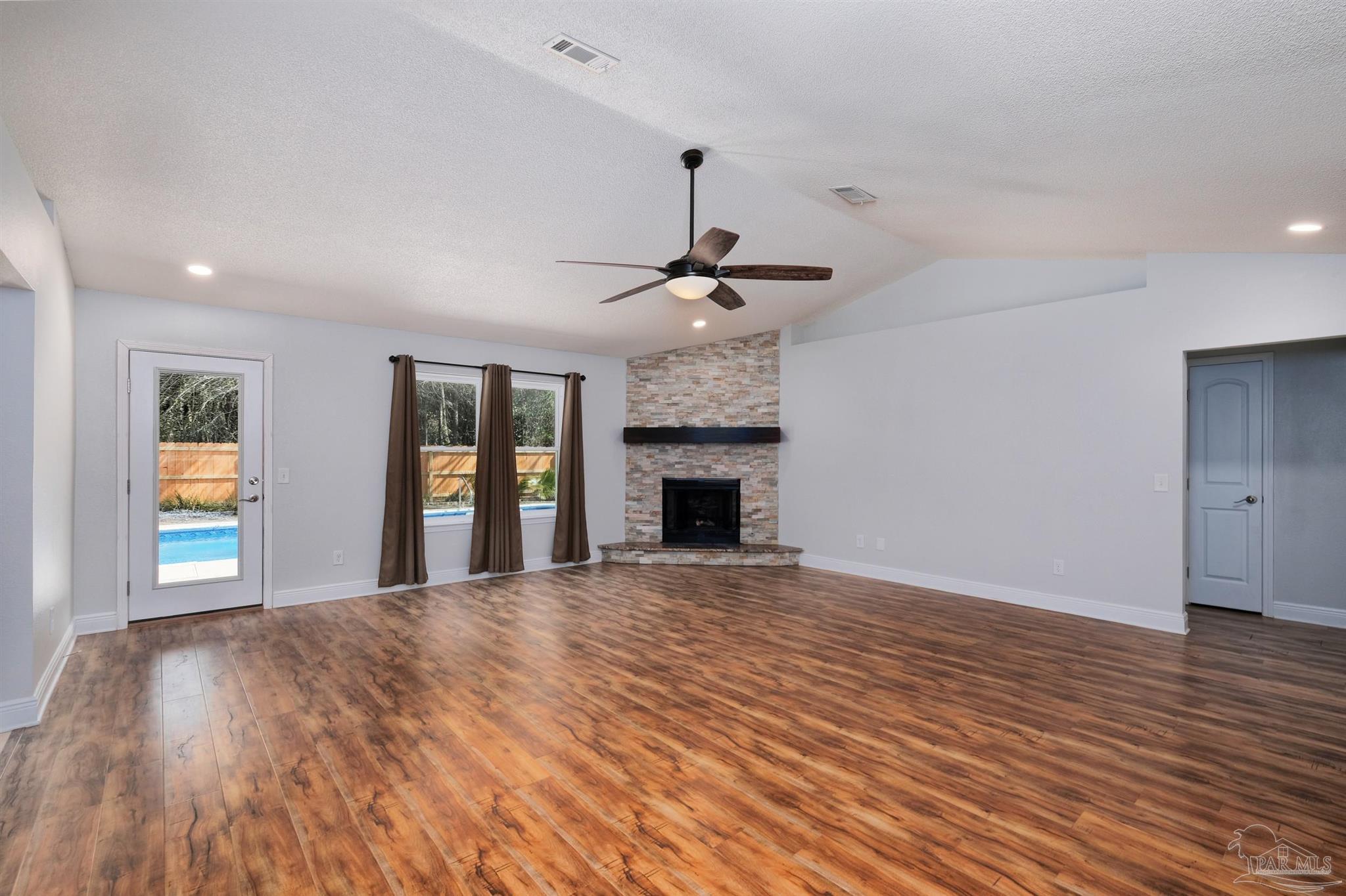 1908 Joshua Drive Cantonment, FL 32533 - Photo 6 of 47 a view of an empty room with wooden floor and a fireplace