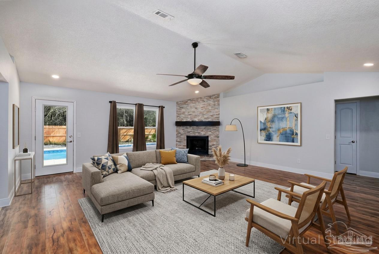 1908 Joshua Drive Cantonment, FL 32533 - Photo 7 of 47 a living room with furniture a fireplace and a table