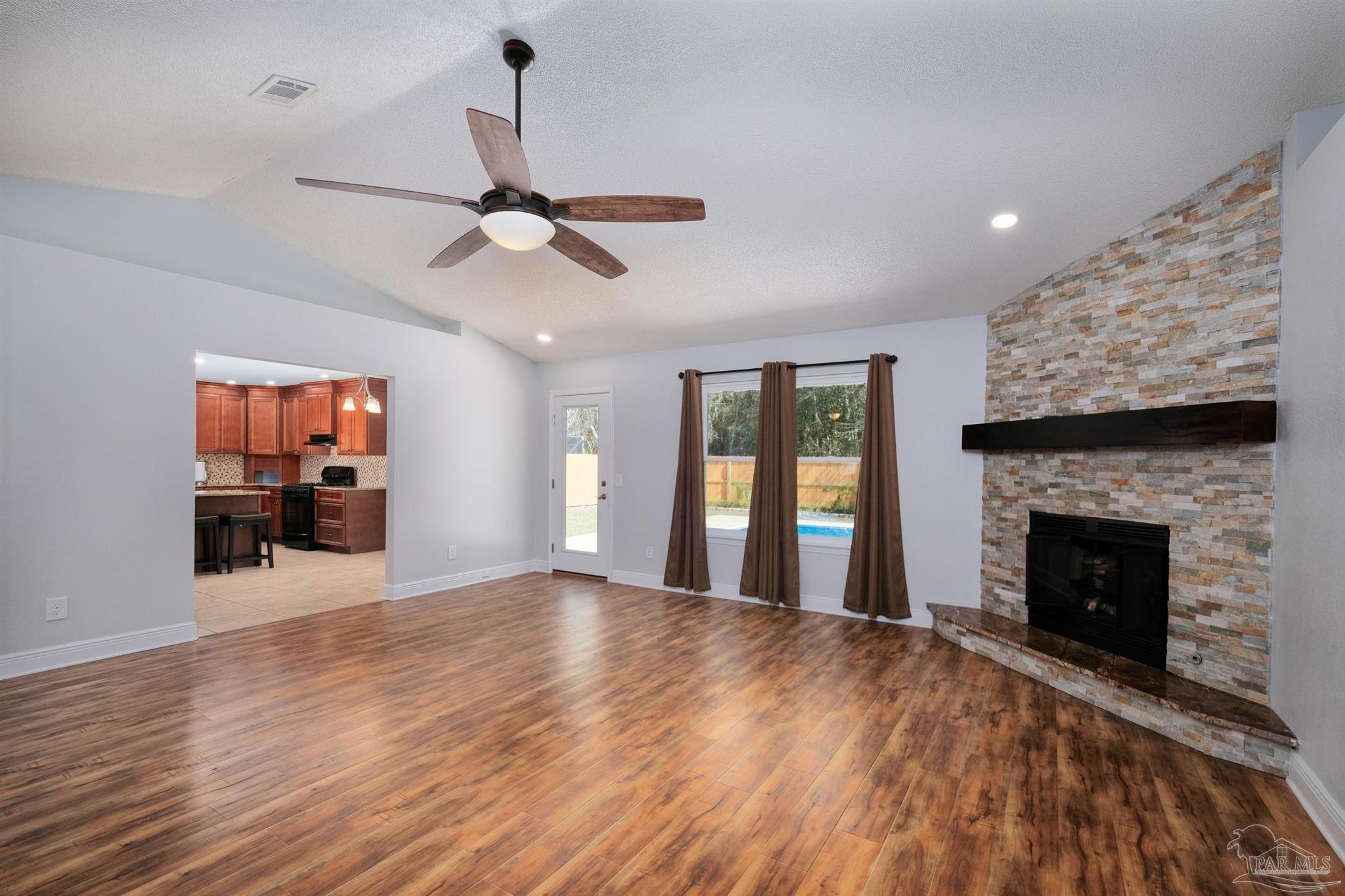 1908 Joshua Drive Cantonment, FL 32533 - Photo 8 of 47 a view of an empty room with wooden floor fireplace and a window