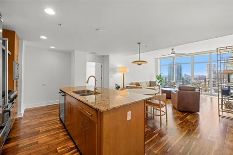 a open kitchen with stainless steel appliances granite countertop a sink stove and wooden floor