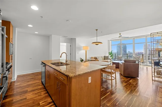 a open kitchen with stainless steel appliances granite countertop a sink stove and wooden floor