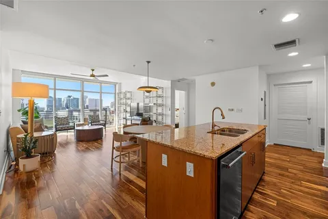 a kitchen with kitchen island granite countertop lots of counter top space and living room