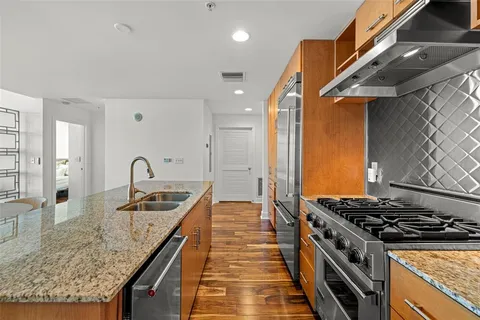 a kitchen with stainless steel appliances granite countertop a stove and a sink