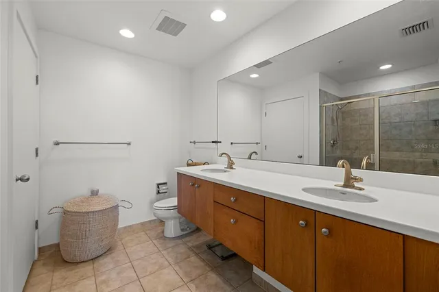 a bathroom with a double vanity sink mirror and toilet