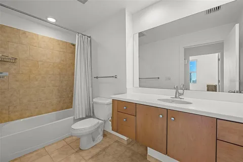a bathroom with a granite countertop sink toilet a large mirror a shower and a bathtub