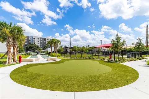 a view of a swimming pool with a yard and plants