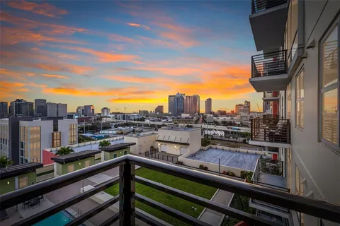 a view of a city from a balcony with chairs