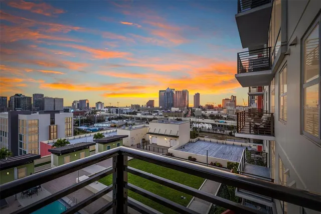 a view of a city from a balcony with chairs