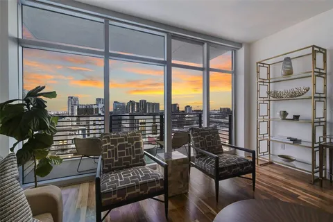 a view of a living room with furniture and a floor to ceiling window