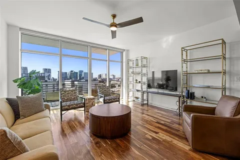 a living room with furniture a lamp and a floor to ceiling window