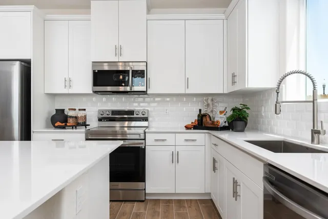 a kitchen with white cabinets and white appliances