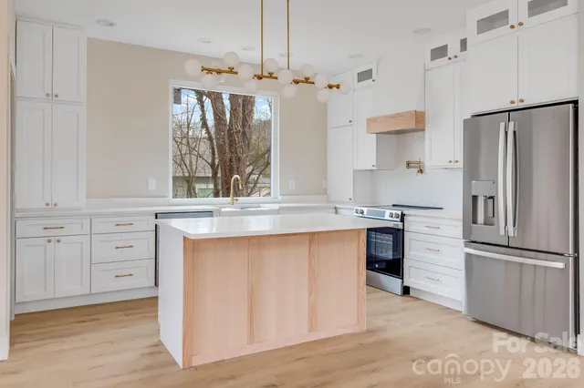 a kitchen with granite countertop a refrigerator and a sink