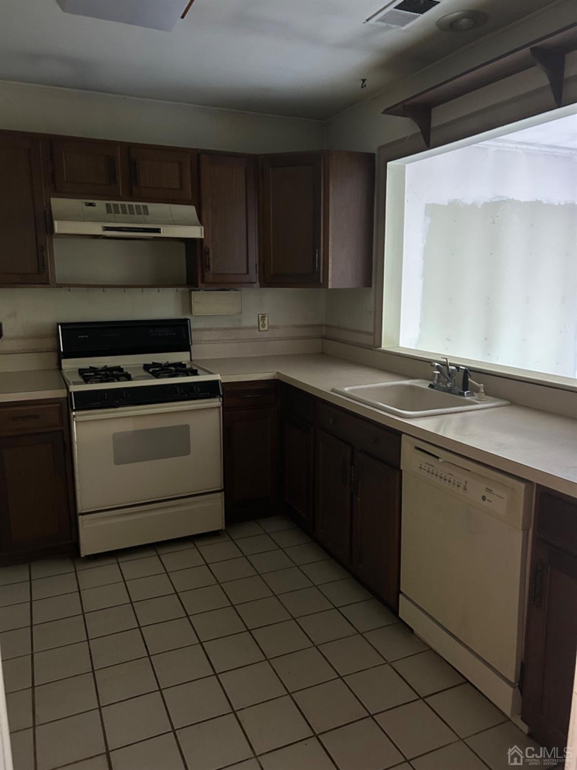 6 Woodbury Road Edison, NJ 08820 - Photo 9 of 18 a kitchen with a sink stove top oven and cabinets