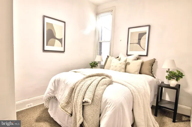 a bedroom with a bed and a painting on the wall