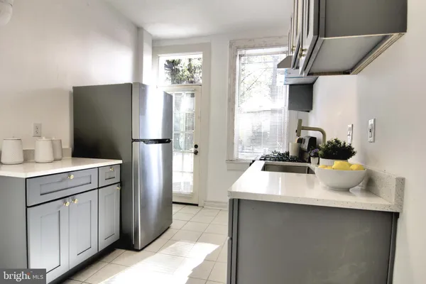 a kitchen with a sink a refrigerator and window