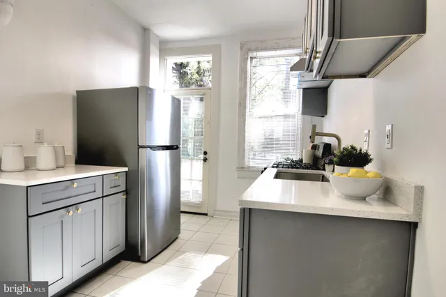 a kitchen with a sink a refrigerator and window