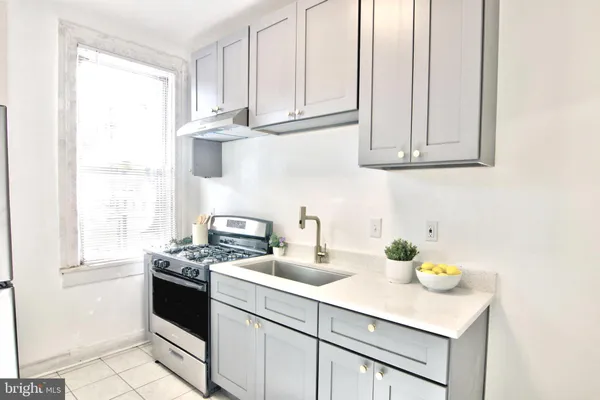 a kitchen with stainless steel appliances granite countertop a sink a stove and a cabinets