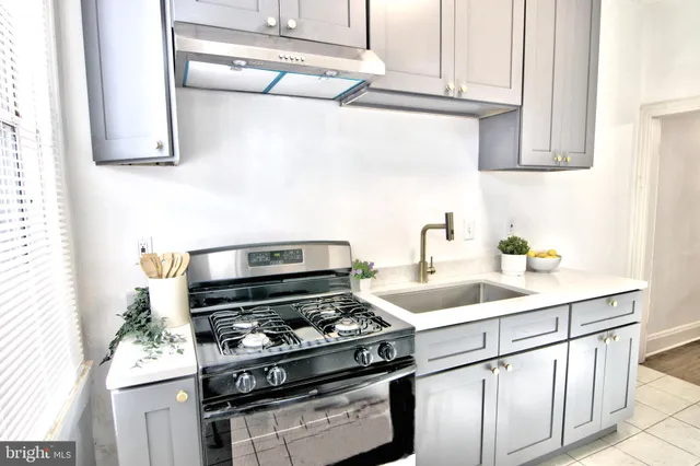 a kitchen with stainless steel appliances granite countertop a sink stove and cabinets