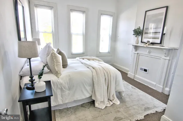 a bedroom with a bed a mirror and windows