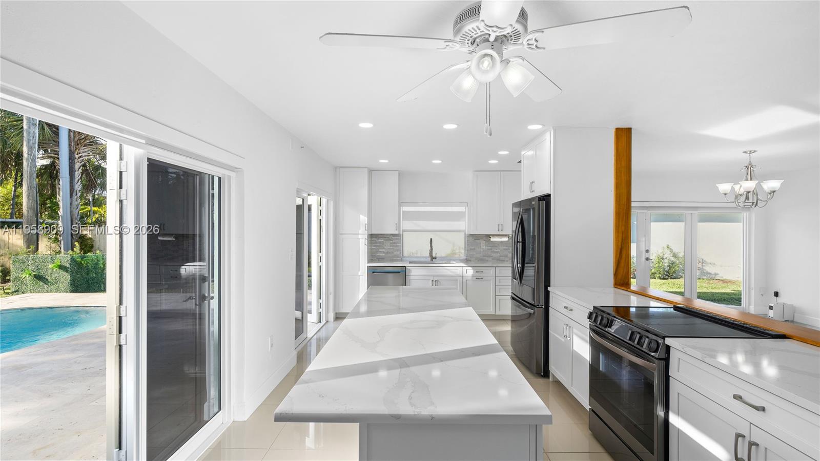 8614 Southwest 102nd Place Miami, FL 33173 - Photo 11 of 47 a view of a kitchen with a stove a refrigerator a sink a dining table and chairs