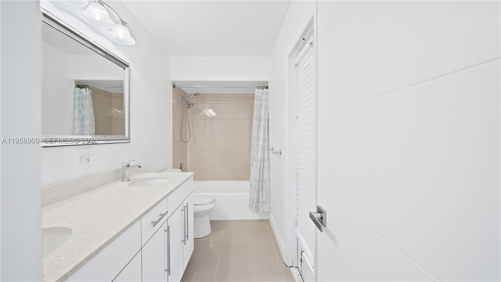 8614 Southwest 102nd Place Miami, FL 33173 - Photo 18 of 44 a bathroom with a sink a mirror and a shower