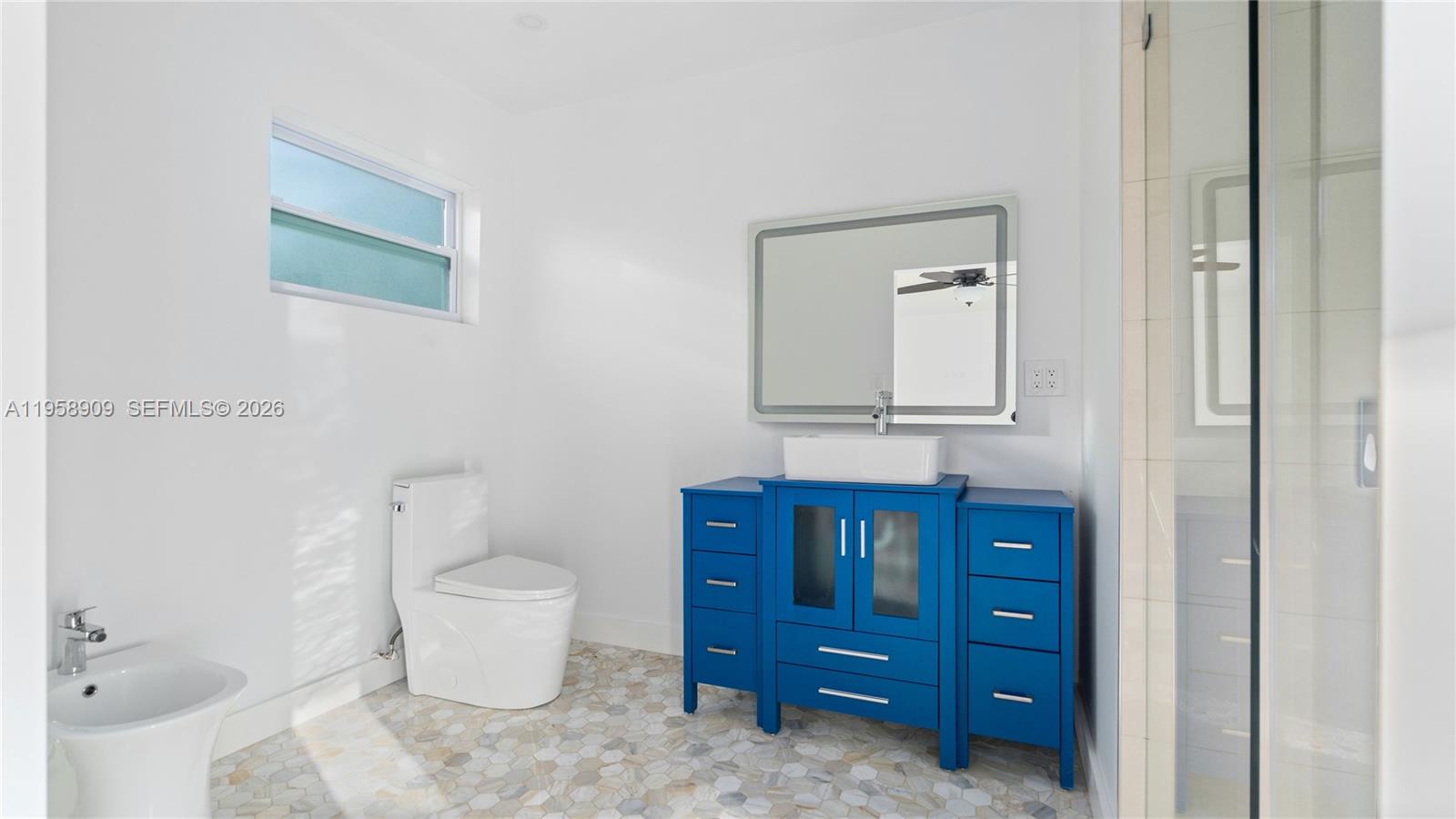 8614 Southwest 102nd Place Miami, FL 33173 - Photo 27 of 47 a bathroom with a toilet a sink and mirror