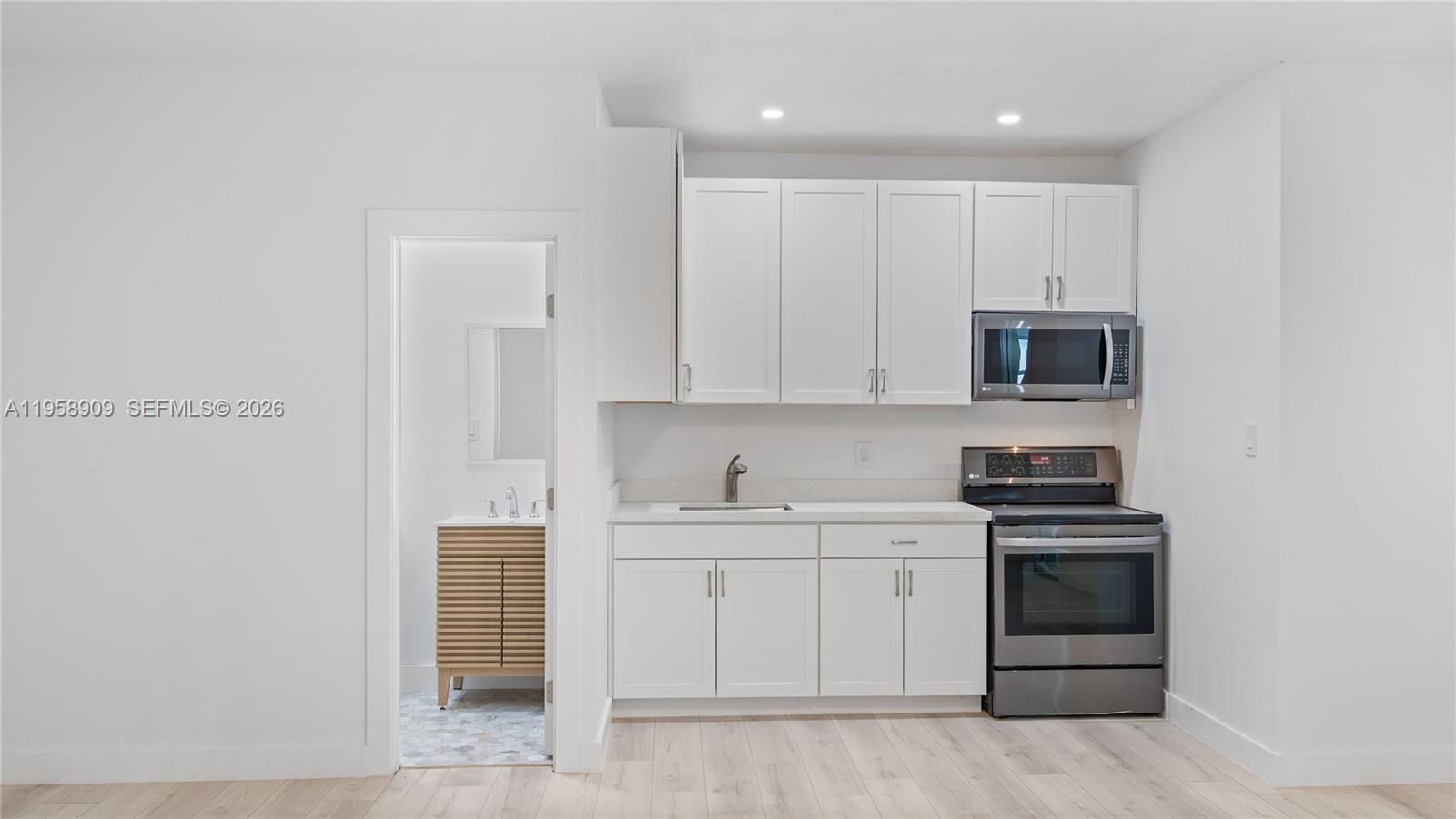 8614 Southwest 102nd Place Miami, FL 33173 - Photo 41 of 44 a kitchen with a sink stove and cabinets