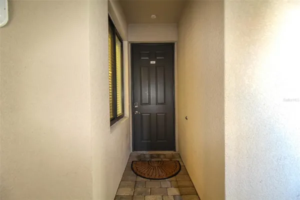 a view of a hallway with wooden floor and a bathroom