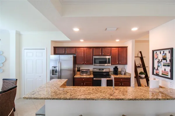 a kitchen with stainless steel appliances granite countertop a stove a sink and a refrigerator