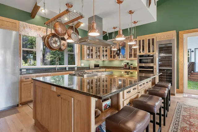 a kitchen with stainless steel appliances granite countertop a sink and a large window