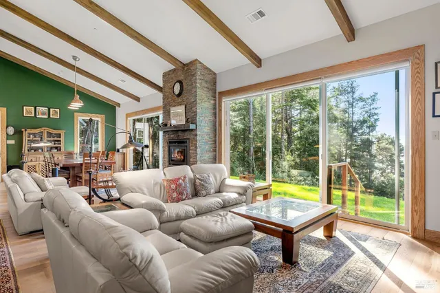 a living room with furniture a table and a large window