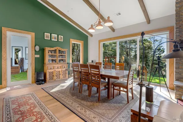 a dining room with furniture a rug and a large window