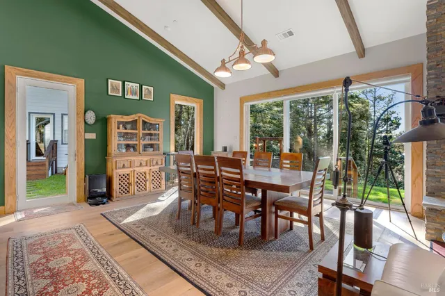 a dining room with furniture a rug and a large window
