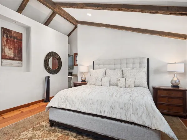 a bedroom with a bed and a lamp on dresser