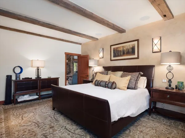 a bedroom with a bed and a lamp on dresser